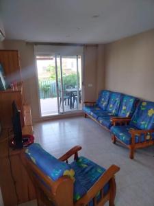 un salon avec des canapés bleus et une télévision dans l'établissement Casa adosada en Daimus solo para familias, à Daimús