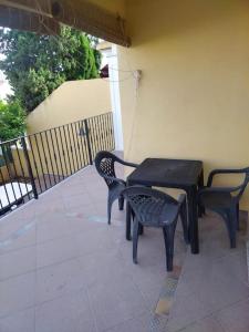 - une table et des chaises noires sur la terrasse dans l'établissement Casa adosada en Daimus solo para familias, à Daimús