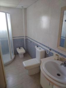 La salle de bains blanche est pourvue de toilettes et d'un lavabo. dans l'établissement Casa adosada en Daimus solo para familias, à Daimús