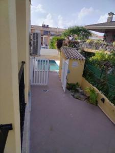 - un balcon d'une maison avec un portail et une piscine dans l'établissement Casa adosada en Daimus solo para familias, à Daimús