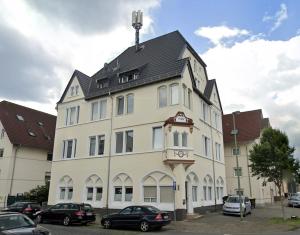 a large white building with a black roof at SHINY HOMES - Bielefeld Mitte in Bielefeld