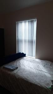 a bedroom with a bed and a large window at Lovely Bedroom with Free parking in Walsall