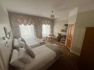 um quarto de hotel com duas camas e um sofá em Ashmore House em Cashel