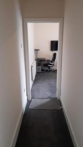 a hallway with a desk and a chair in a room at Lovely Bedroom with Free parking in Walsall