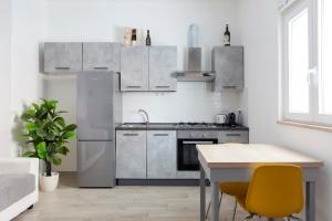 a kitchen with stainless steel appliances and a table at Luciano Secret Garden Apartment in Rome