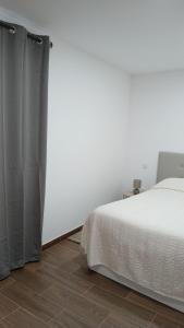 a bedroom with a bed and a white wall at Alojamento Local Casa da Eira in Murça