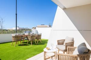 Un patio con sillas y una mesa en un tejado. en Luxury House Chaparral Golf E70 by AORA STAY, en La Cala de Mijas