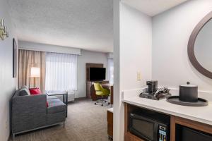 a living room with a couch and a television in a hotel room at Hampton Inn & Suites Hartford-Manchester in Manchester