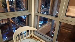 a white chair sitting in a room with two windows at The solid residence - Elbon the stay by haeundae in Busan