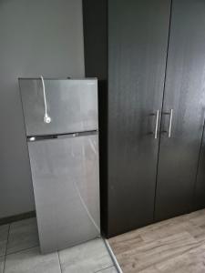 una nevera de acero inoxidable en una cocina junto a armarios en Apartament Bunsha Kraków, en Cracovia 2 fotos más