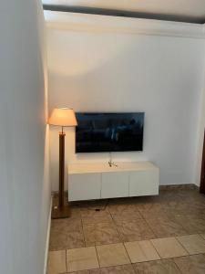 a living room with a tv on a white wall at two flat in Douala