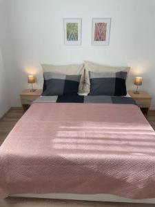 a bedroom with a large bed with a pink blanket at Magnolia in Trnávka