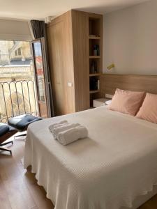 a bedroom with a white bed with two towels on it at Acariciando la Catedral Vista espectacular in Burgos