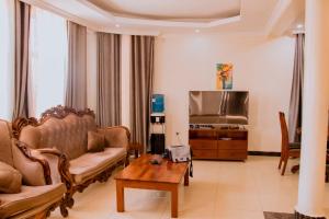 a living room with a couch and a tv at SUNFLOWER HOMES VILLAa in Kigali