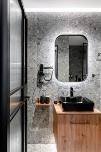 baño con lavabo negro y espejo en Snob Athens, en Atenas