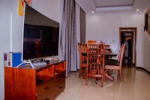 uma sala de estar com uma secretária e uma mesa com cadeiras em SUNFLOWER HOMEs VILLA em Kigali