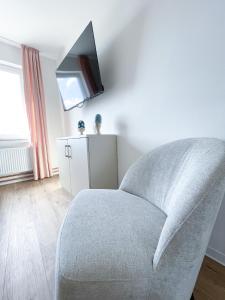 uma sala de estar com uma cadeira e uma televisão em Ferienwohnung auf dem Hof Postma em Lambrechtshagen
