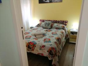 a bedroom with a bed with a floral bedspread at I mori di Sicilia in Giardini Naxos