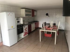 uma cozinha com um frigorífico branco, uma mesa e cadeiras em Maison POUR OUVRIERS seulement PAS DE TOURISME, NI FAMILLE em Stains