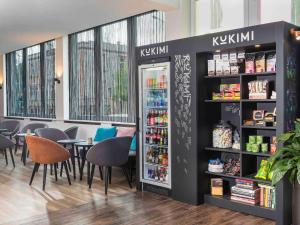 a restaurant with a refrigerator and tables and chairs at ibis Styles Halle in Halle an der Saale