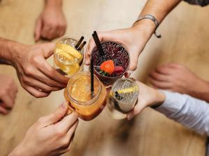 um grupo de pessoas segurando bebidas em suas mãos em ibis Styles Halle em Halle an der Saale