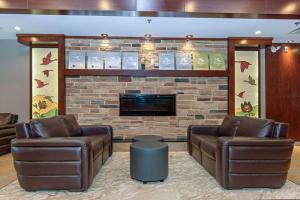a lobby with two leather chairs and a fireplace at Quality Inn & Suites in Val-dʼOr