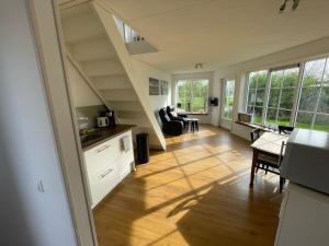 a kitchen and living room with a staircase in a house at Blossom Barn Lodges in Oudewater
