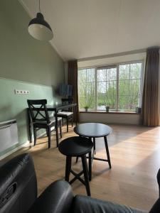 uma sala de estar com mesas e cadeiras e um sofá em Blossom Barn Lodges em Oudewater