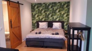 um quarto com uma cama com uma grande pintura na parede em Blossom Barn Lodges em Oudewater