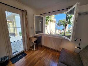 a living room with a couch and a large window at Hôtel de Charme Brise Marine in Saint-Jean-Cap-Ferrat