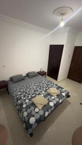 een slaapkamer met een bed met een zwart-wit dekbed bij Appartement familiales in Al Hoceïma