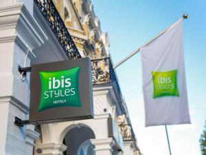 a sign on the side of a building with two flags at ibis Styles London Gloucester Road in London