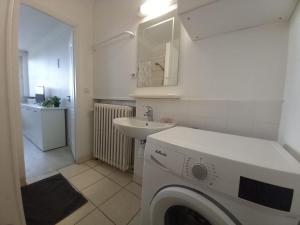 ein Badezimmer mit einer Waschmaschine und einem Waschbecken in der Unterkunft D St-Quentin-en -Yvelines Plusieurs appartements in Trappes