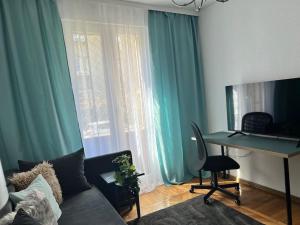 a living room with a couch and a desk with a computer at Groundfloor Rahmaninov in Bucharest