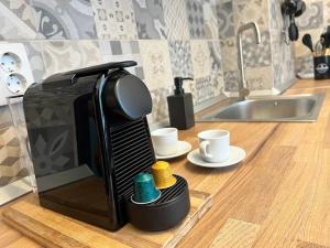 a coffee maker sitting on a kitchen counter with two cups at Groundfloor Rahmaninov in Bucharest