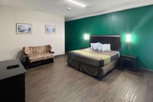 Pokój hotelowy z łóżkiem i krzesłem w obiekcie Rodeway Inn w mieście Georgetown