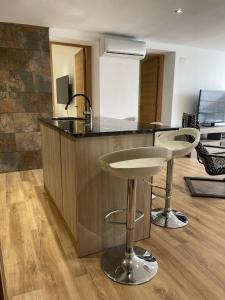 a kitchen with two bar stools and a counter at SOLGUEST Apt ESTEPONA CENTRO 1ª LINEA DE PLAYA in Estepona