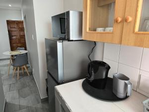 a kitchen with a stainless steel refrigerator with a microwave at No8@Mosselbay - Central Mosselbay 1 Bedroom Apartment in Mossel Bay