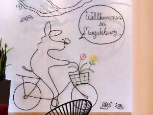 un dibujo de una mujer montando una bicicleta con una planta en ibis Styles Magdeburg en Magdeburgo