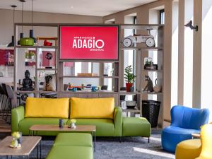 - un salon avec un canapé vert et une télévision dans l'établissement Aparthotel Adagio Bremen City, à Brême