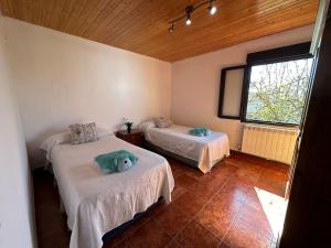 Habitación con 2 camas y un osito de peluche en la cama en Increíble Casita de Pueblo. en Ugena