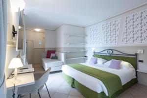 una camera con letto, scrivania e sedia di Hotel du Lac Varenna a Varenna