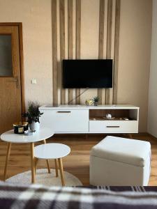 una sala de estar con un centro de entretenimiento blanco con TV de pantalla plana en Apartments Horizont Mostar, en Mostar