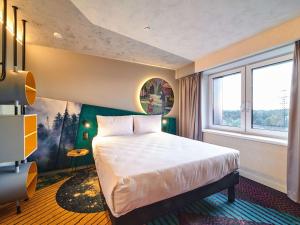 1 dormitorio con cama y ventana grande en ibis Styles Chelyabinsk, en Chelyabinsk