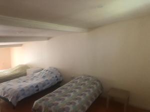 a room with two beds and a table in it at Maison POUR OUVRIERS seulement PAS DE TOURISME, NI FAMILLE in Stains