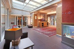 a living room with a large television and a living room with a couch at Hotel Goldener Karpfen in Aschaffenburg