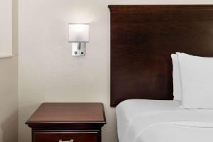 um quarto de hotel com uma cama e uma mesa com um candeeiro em Baymont by Wyndham Houston Brookhollow em Houston