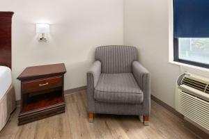 a hospital room with a chair and a table at Baymont by Wyndham Houston Brookhollow in Houston