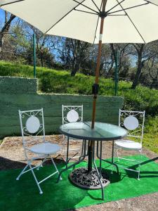 a table and two chairs with an umbrella at La Finca de Los Pisones in Lloreda