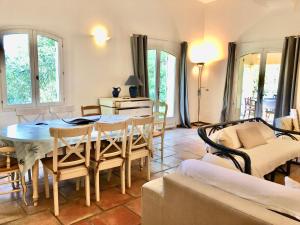 ein Wohnzimmer mit Tisch und Stühlen in der Unterkunft Terre de Sel in Grimaud
